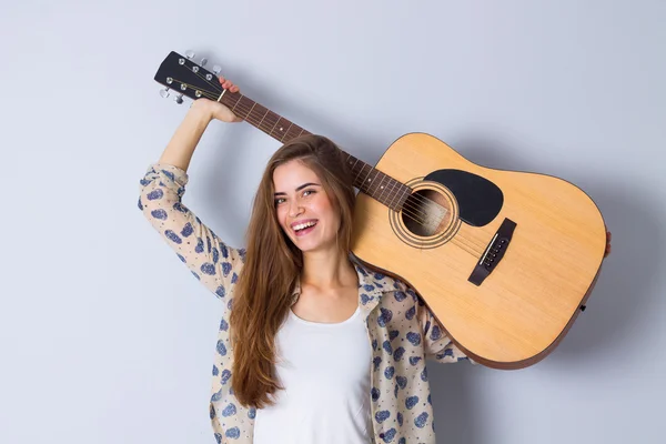 Mujer joven sosteniendo una guitarra —  Fotos de Stock