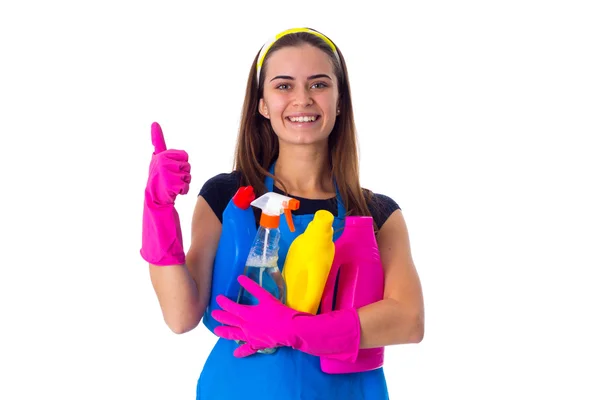 Жінка в фартусі тримає миючі засоби — стокове фото