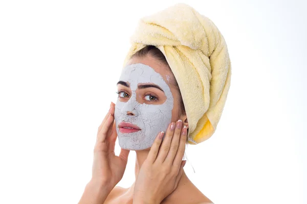 Mujer con toalla en la cabeza y máscara cosmética en la cara — Foto de Stock