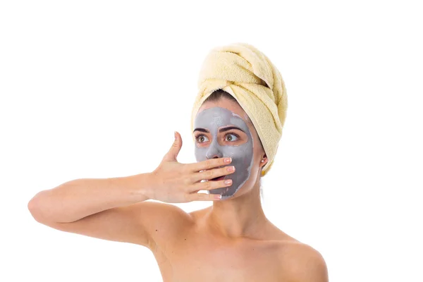 Femme avec serviette sur la tête et masque cosmétique sur le visage — Photo