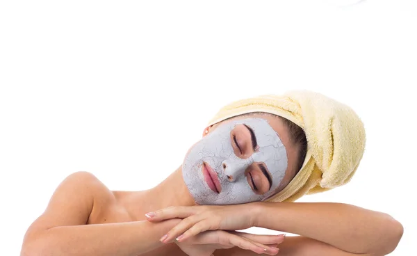 Žena s ručníkem na hlavě a kosmetická maska na obličej — Stock fotografie