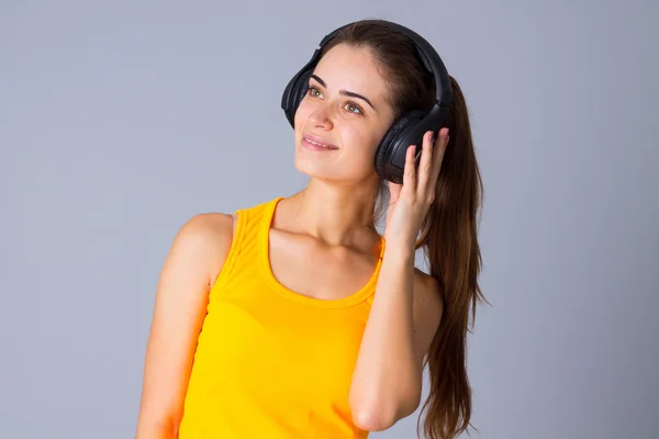 Jovem mulher em fones de ouvido — Fotografia de Stock