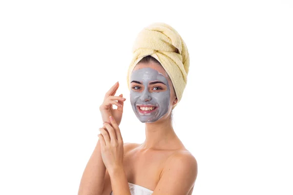 Vrouw met handdoek op haar hoofd en cosmetische masker op haar gezicht — Stockfoto