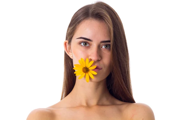 Mujer joven sosteniendo flor amarilla en sus labios — Foto de Stock
