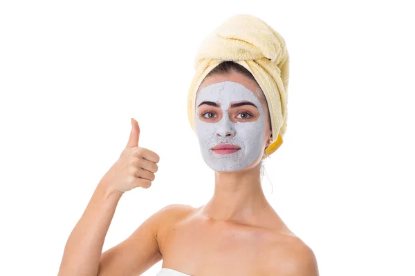 Vrouw met handdoek op haar hoofd en cosmetische masker op haar gezicht — Stockfoto