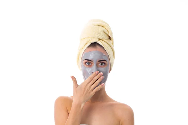 Femme avec serviette sur la tête et masque cosmétique sur le visage — Photo