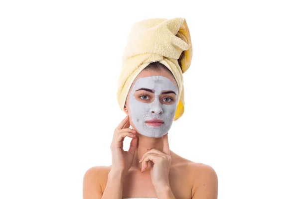Kobieta z ręcznikiem na jej głowie i kosmetycznych maska na twarz — Zdjęcie stockowe