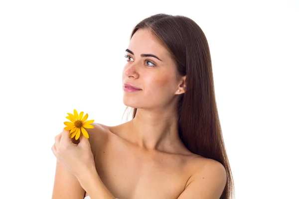 Jonge vrouw met lang haar bedrijf gele bloem — Stockfoto