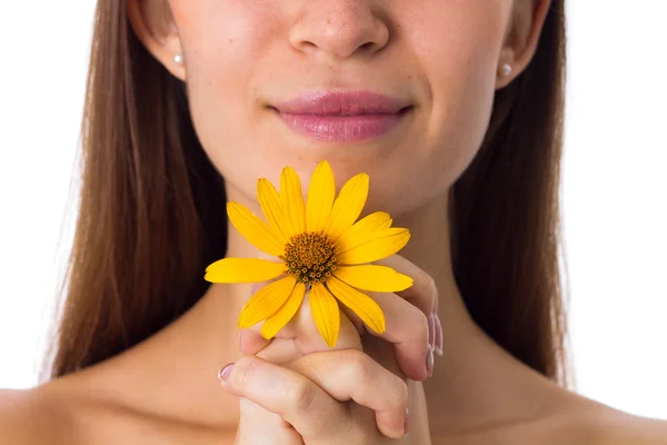 Mladá žena s dlouhými vlasy drží žlutý květ — Stock fotografie