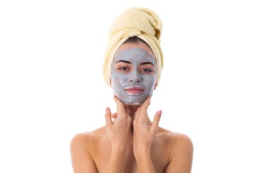 Havlu kafa ve kozmetik maskesi yüzünde kadınla