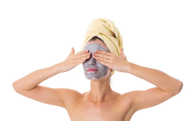 Femme avec serviette sur la tête et masque cosmétique sur le visage — Photo