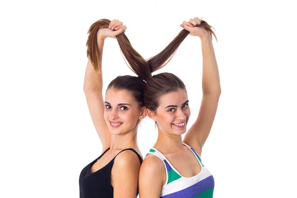 Dos mujeres jóvenes sosteniendo su cabello — Foto de Stock