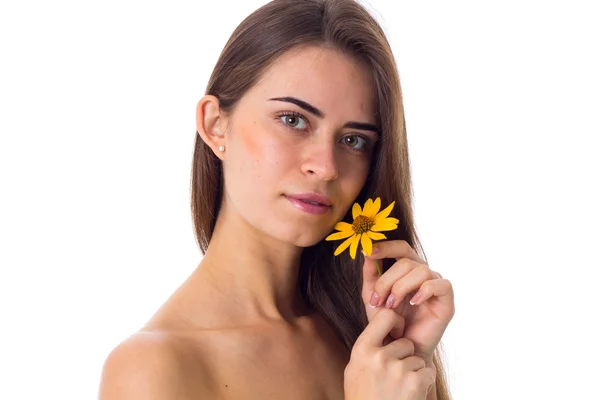 Ung kvinna med långt hår håller gul blomma — Stockfoto
