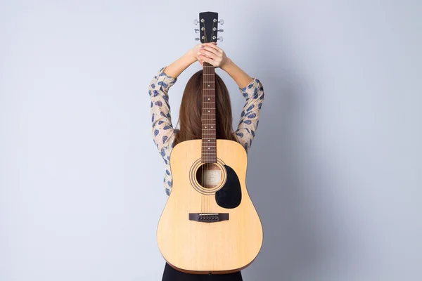 Νέα γυναίκα που κρατά μια κιθάρα — Φωτογραφία Αρχείου