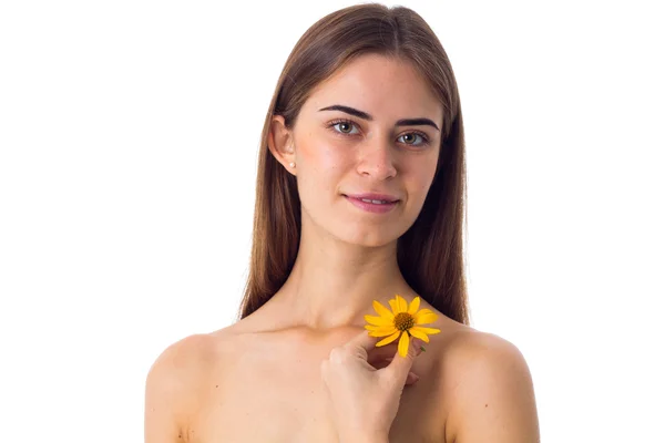 Młoda kobieta z długimi włosami, trzymając kwiat żółty — Zdjęcie stockowe