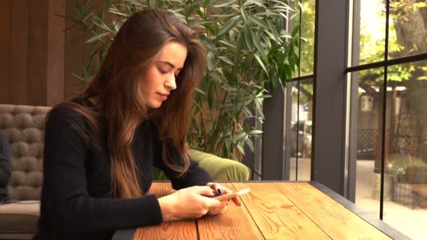 Giovane donna al caffè utilizzando il telefono cellulare — Video Stock