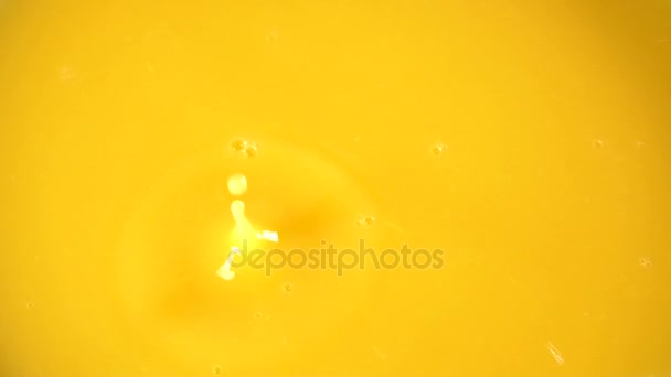 Sliced orange falling into orange juice — Stock Video