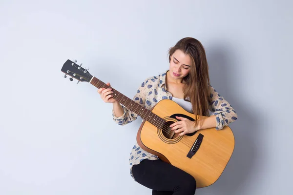 Mujer joven sosteniendo una guitarra —  Fotos de Stock