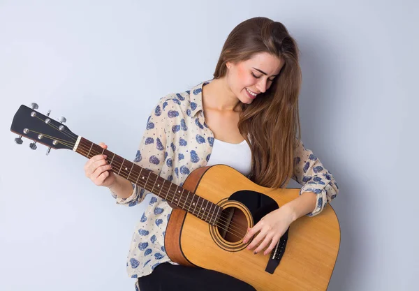 Молода жінка тримає гітару — стокове фото