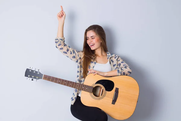 Mujer joven sosteniendo una guitarra —  Fotos de Stock