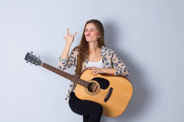 Mujer joven sosteniendo una guitarra —  Fotos de Stock