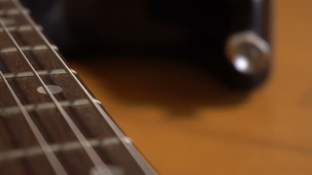 Cámara deslizándose lentamente sobre la guitarra eléctrica — Vídeos de Stock