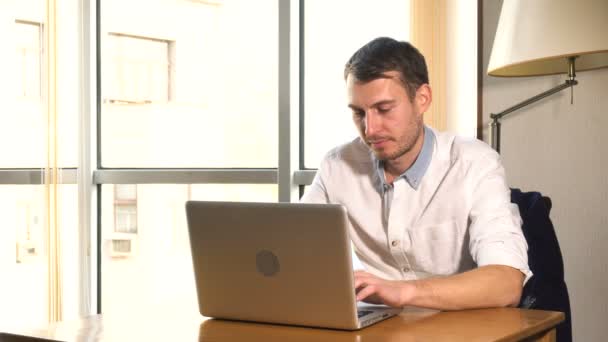 Hombre joven trabajando en el ordenador portátil — Vídeos de Stock