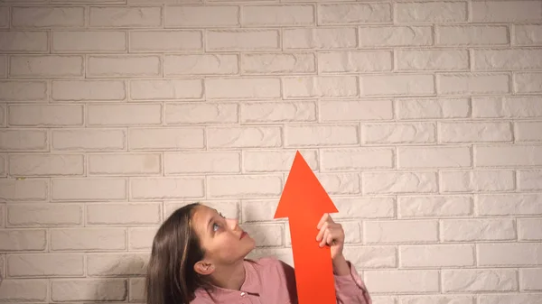 Ragazza che tiene uno striscione con freccia rossa — Foto Stock