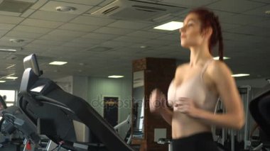 Spor salonunda treadmill çalıştıran çekici beyaz genç teen