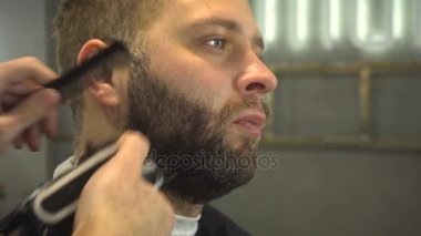 Berber dükkanındaki adamın sakalını kesmek.