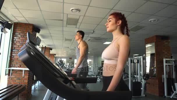 Fitness férfi és nő, séta a futópad — Stock videók