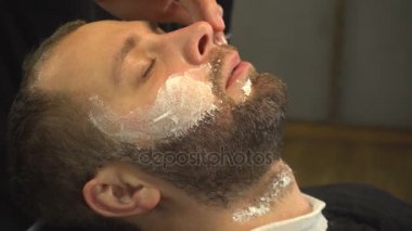 Barberman sakallı adamın yüzünü yumuşak krem kullanma