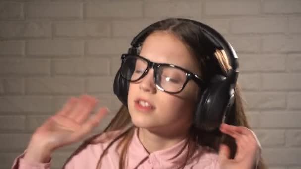Дівчина-підліток в навушниках слухає музику — стокове відео