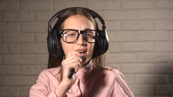 Teenager girl in headphones listening music and singing — Stock Video