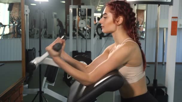 Mujer en forma haciendo ejercicio en bíceps en máquina de bíceps — Vídeo de stock