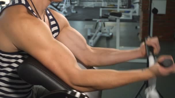 Silný muž dělá cvičení biceps stroje — Stock video