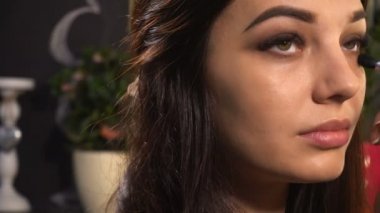 Makyaj sanatçısı kadın modeli için makyaj yapar