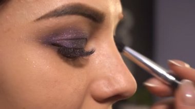 Makyaj sanatçısı kadın modeli için makyaj yapar