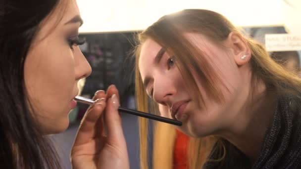 Макияж художник делает макияж для женщины модели — стоковое видео