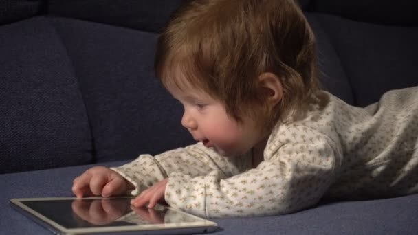 Liten söt baby flicka leker med touchpad — Stockvideo