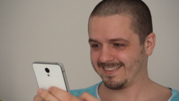 Beau jeune homme utilisant un smartphone et souriant — Video