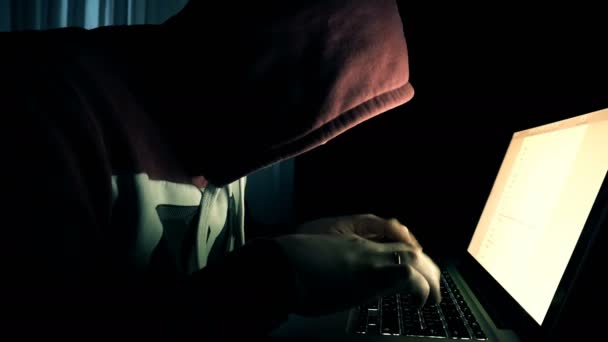 Homme hacker dans un capot fonctionne sur un ordinateur — Video