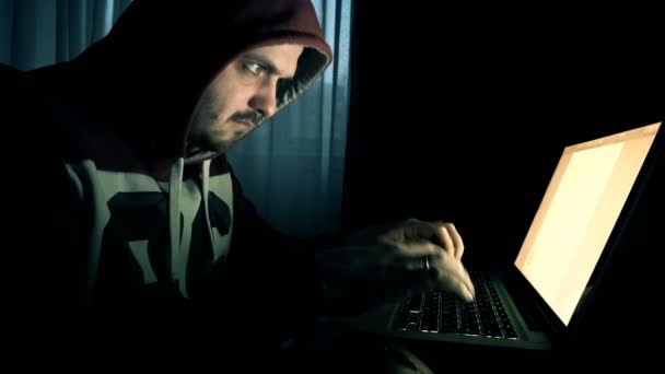 フードで男性のハッカーがコンピューターで動作します。 — ストック動画