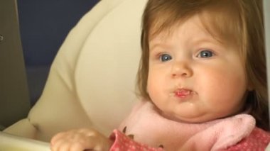 Bebek oturur bir çocuk küçük tablo ve annem onu beslemeleri