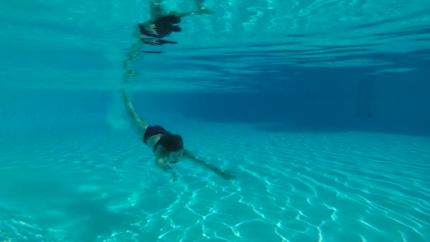 Szépség slowmotion, fiatal nővel, víz alatti úszás a medencében — Stock videók