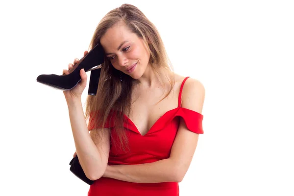 Young woman in red dress holding shoes — Stock Photo, Image