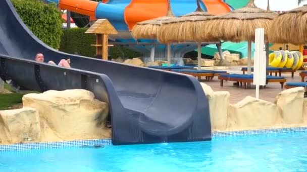 Man sliding in water park from waterslide — Stock Video