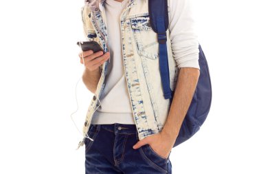 Sırt çantası, akıllı telefon ve kulaklık ile genç adam