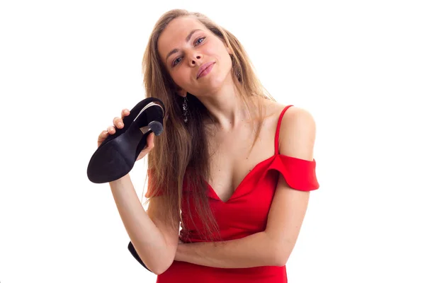 Young woman in red dress holding shoes — Stock Photo, Image
