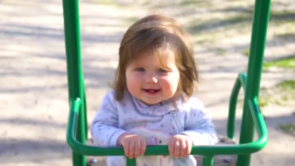 Sonriente bebé niña swingin en swing — Vídeo de stock